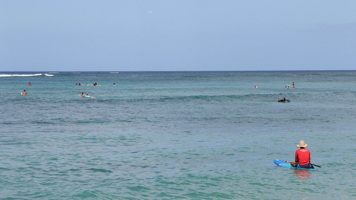 A paddler sits off Waikiki Beach in Honolulu, Saturday, July 25, 2020, as Hurricane Douglas approaches.