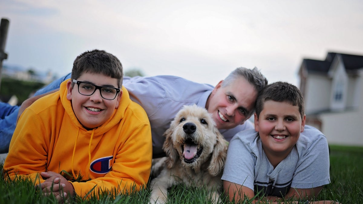 Jason Wright and his sons posing with family dog Pilgrim in last photoshoot before he passed