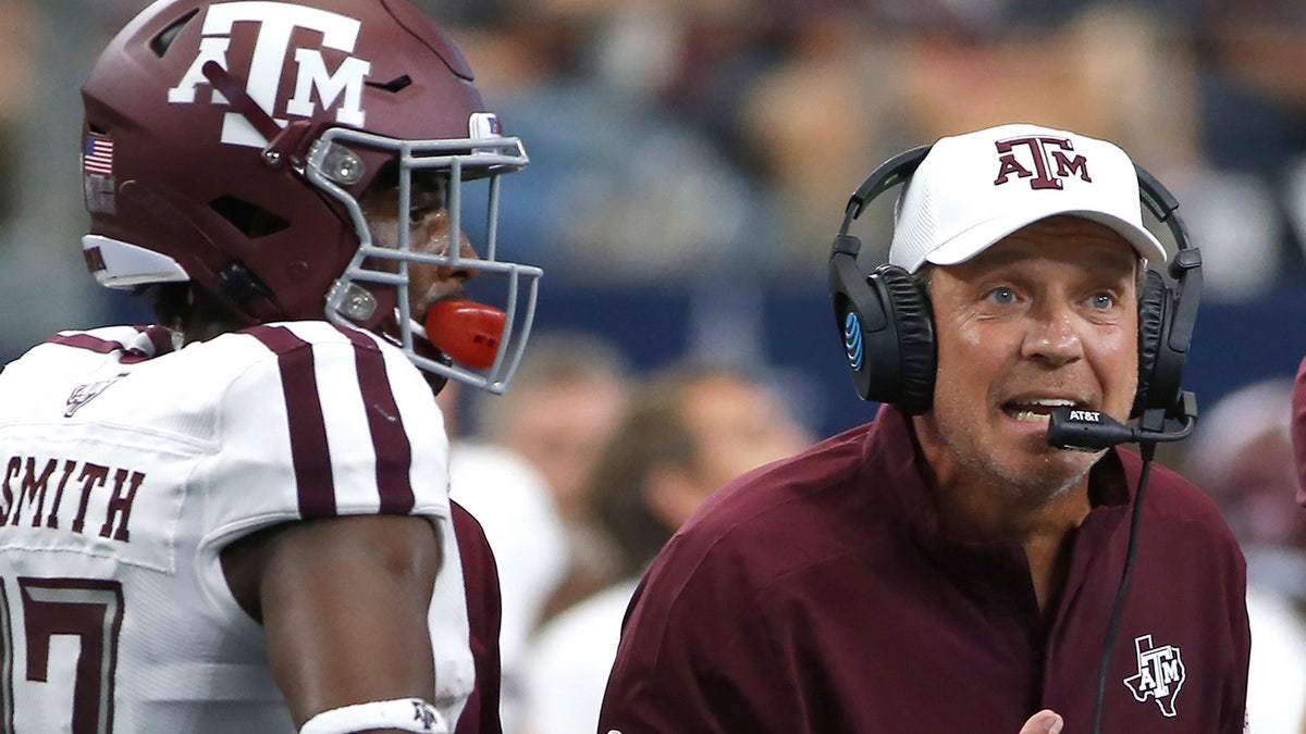 In this Sept. 28, 2019, file photo, Texas A&M head coach Jimbo Fisher talks with his team as wide receiver Ainias Smith (17) looks on as they play Arkansas during the first half of an NCAA college football game in Arlington, Texas. (AP Photo/Ron Jenkins, File)