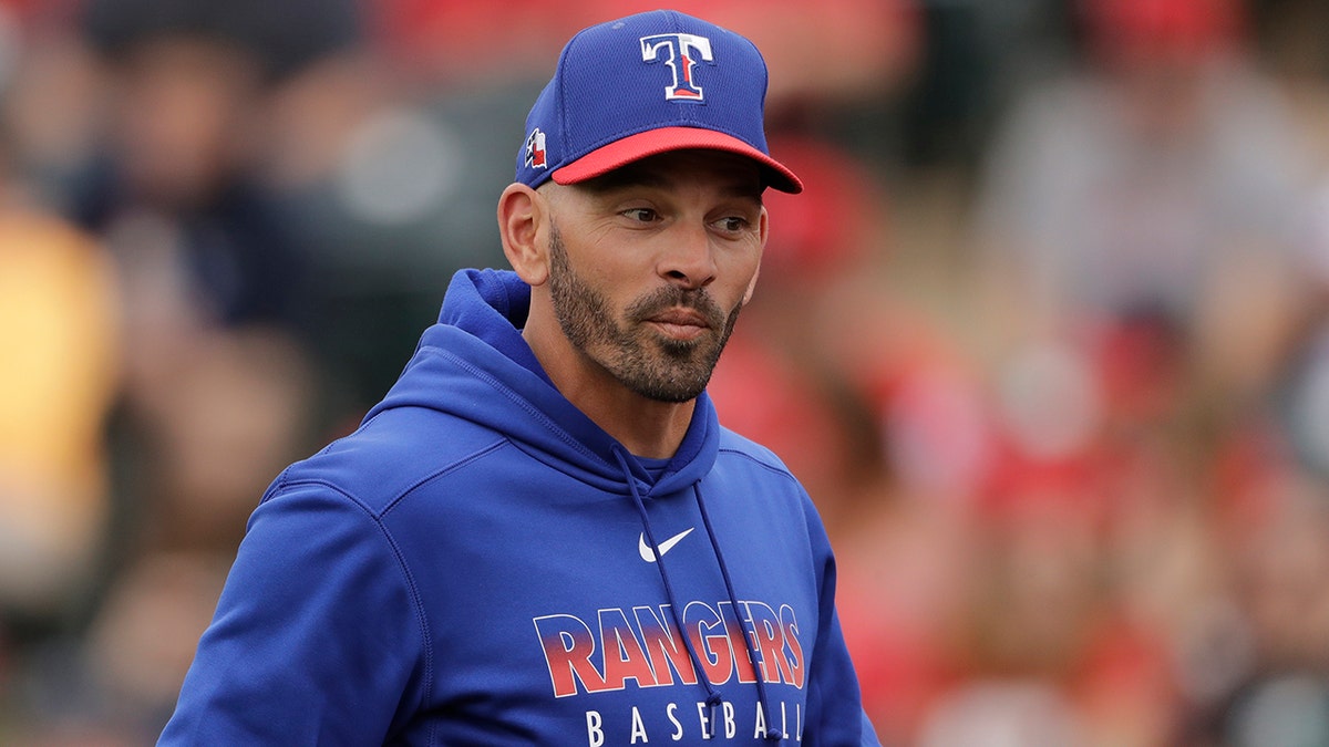 FILE - In this Friday, Feb. 28, 2020, file photo, Texas Rangers manager Chris Woodward walks back to the dugout after making a pitching change during the third inning of a spring training baseball game against the Los Angeles Angels, in Tempe, Ariz. (AP Photo/Charlie Riedel, File)