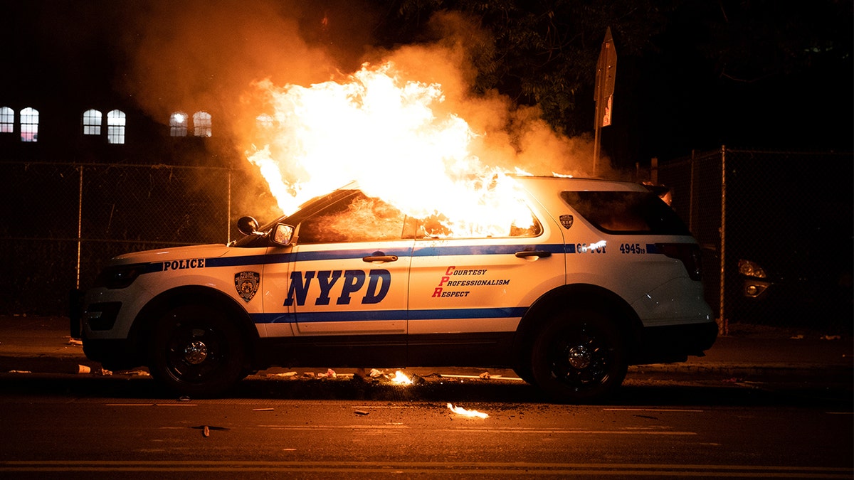 An NYPD police car is set on fire as protesters clash with police during a march against the death in Minneapolis police custody of George Floyd, in the Brooklyn borough of New York City, U.S., May 30, 2020. (REUTERS/Jeenah Moon)