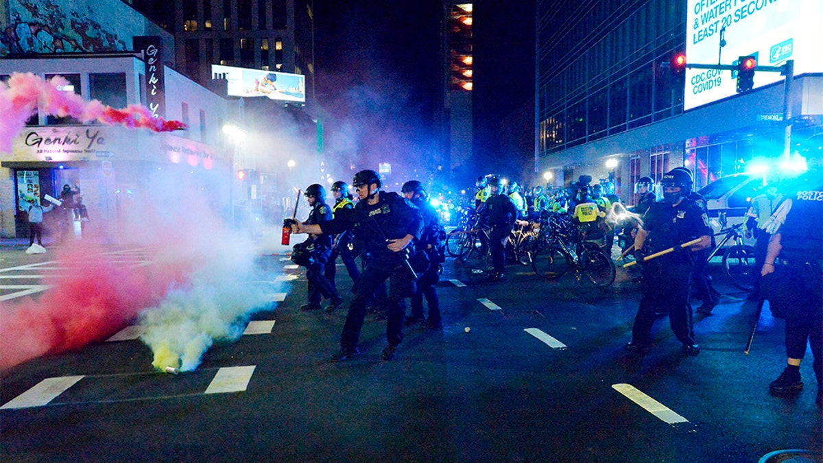 Smoke rises around police as they spray pepper spray during clashes with protesters after a May 31 demonstration over the death of George Floyd, an unarmed black man who died in Minneapolis Police custody, in Boston. A Boston-area man was federally charged Thursday with shooting at a group of police officers after a protest against police brutality. (Photo by Joseph Prezioso / AFP) (Photo by JOSEPH PREZIOSO/AFP via Getty Images)