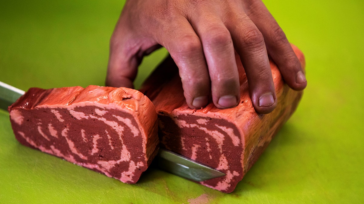 A chef cuts a piece of uncooked 3D printed plant-based steak mimicking real beef and produced by Israeli startup Redefine Meat during a demonstration for Reuters at their facility in Rehovot, Israel.