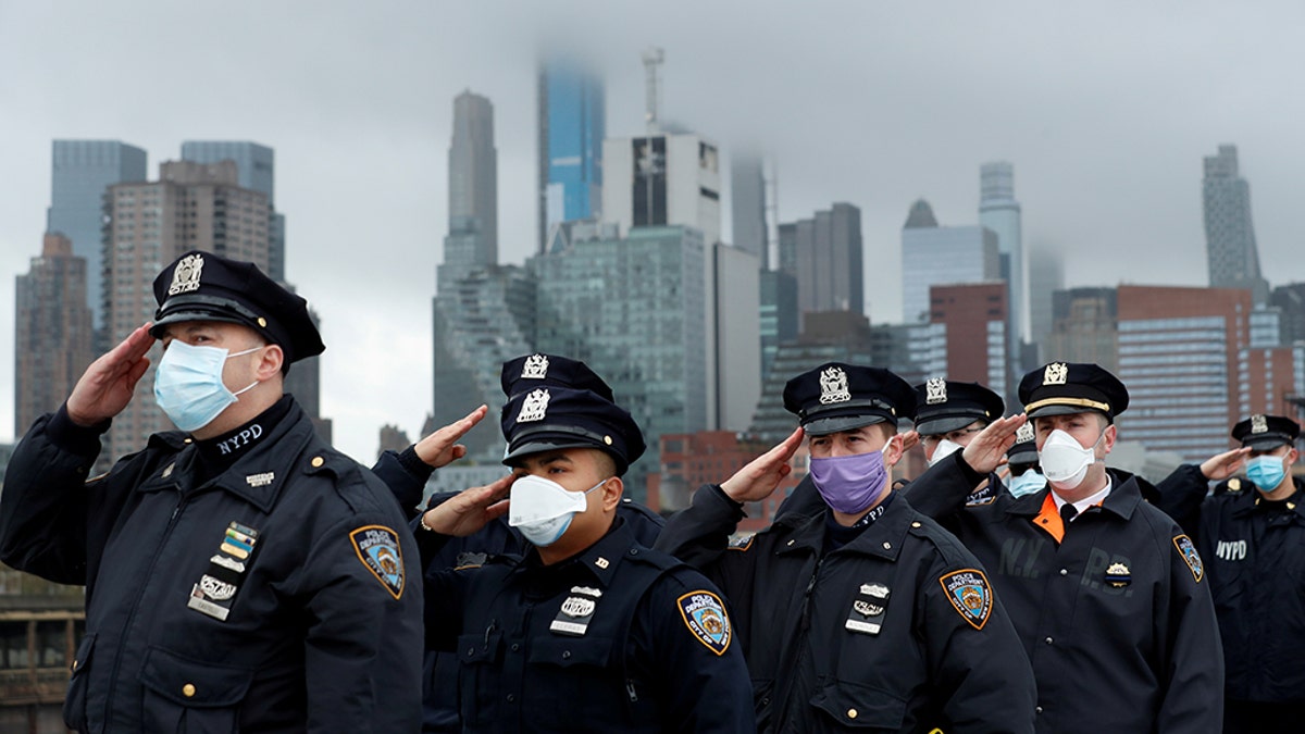 Police officers from the NYPD salute as the U.S. Navy hospital ship USNS Comfort departs Pier 90 in Manhattan under heavy fog to return to its home port of Norfolk, Virginia, after treating patients during the outbreak of the coronavirus (COVID-19) in New York City New York, U.S., April 30, 2020. (REUTERS/Lucas Jackson)
