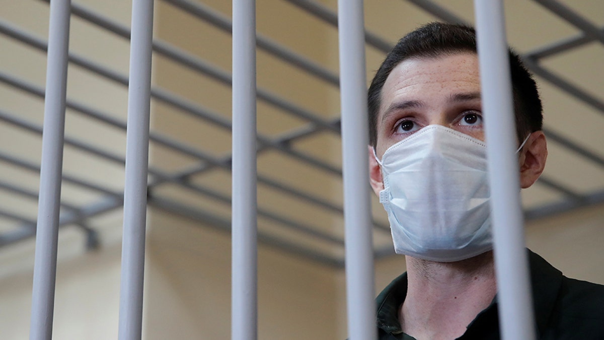 Former U.S. Marine Trevor Reed, who was detained in 2019 and accused of assaulting police officers, stands inside a defendants' cage during a court hearing in Moscow, Russia July 30. (Reuters/Maxim Shemetov)