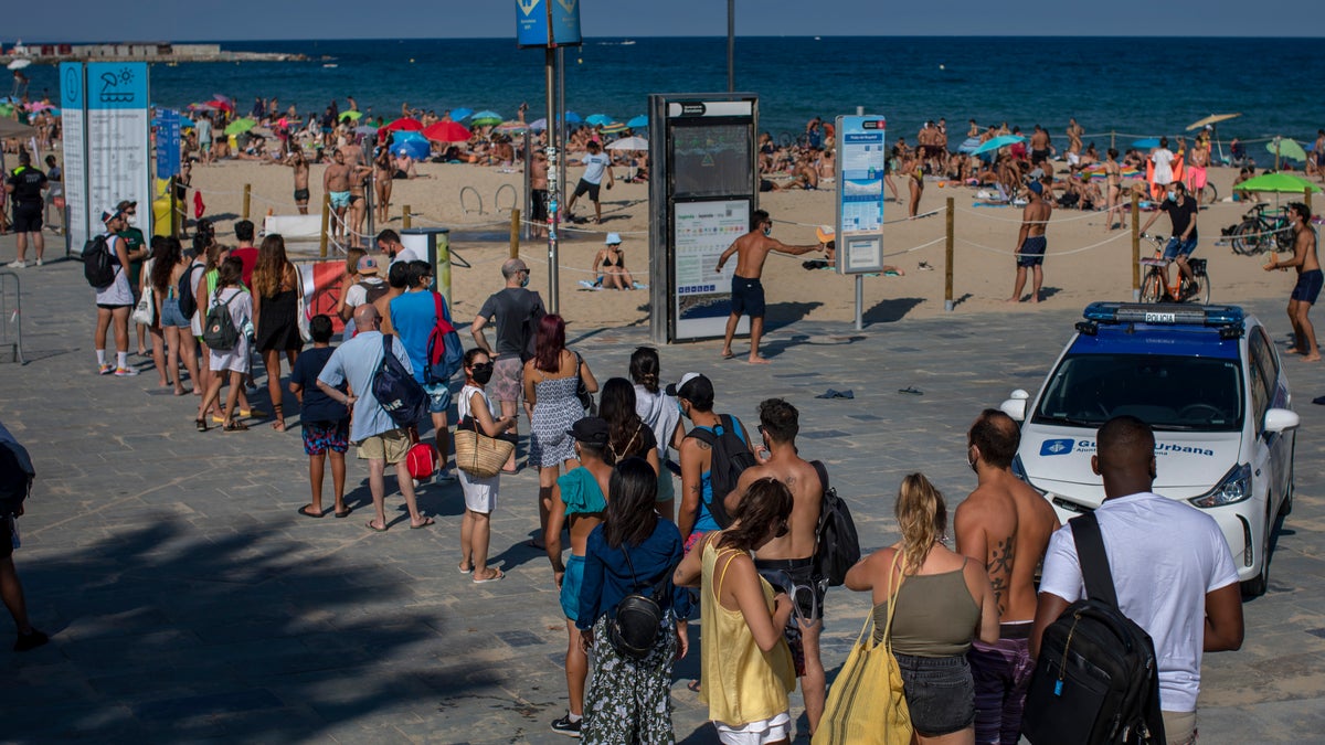 People wait to enter a beach that was closed by police due to crowding in Barcelona on Saturday. (AP)