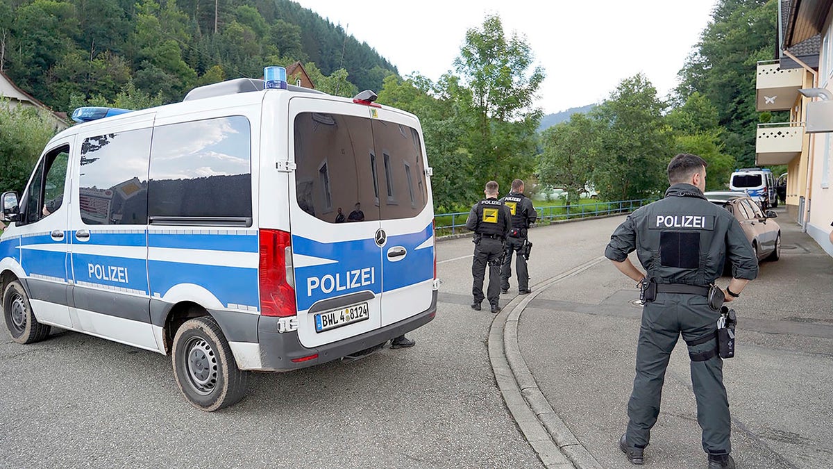 Police officers stand in front of a driveway in a forest area near Oppenau, Germany on Friday. (Benedikt Spether/dpa via AP)