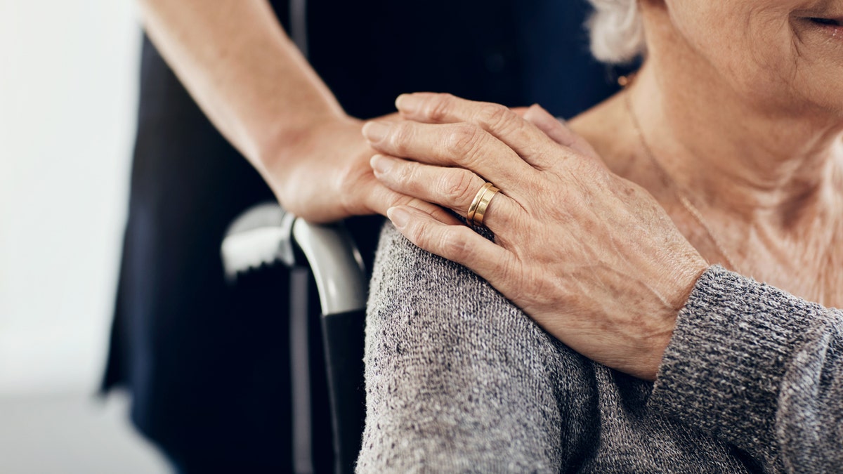 Caregiver comforts elderly woman