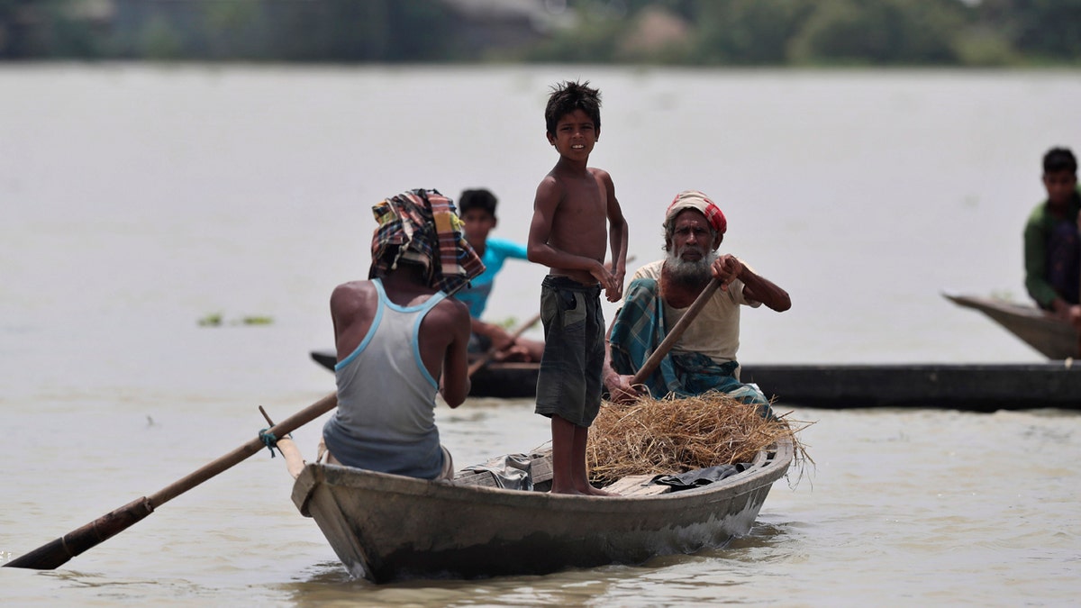 Indian flood affected people row country boats in Gagolmari village, Morigaon district, Assam, India, July 14.