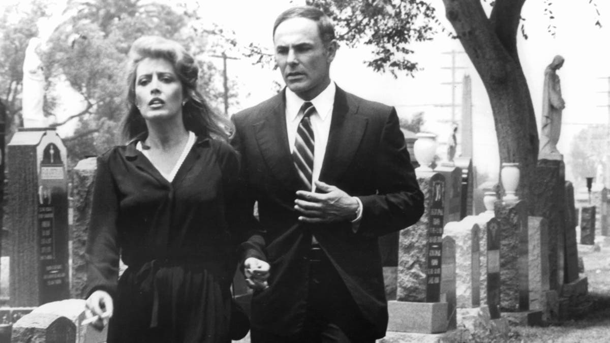 Ronee Blakley and John Saxon walking through a cemetery in a scene from the film 'A Nightmare On Elm Street,' 1984. (Photo by New Line Cinema/Getty Images)