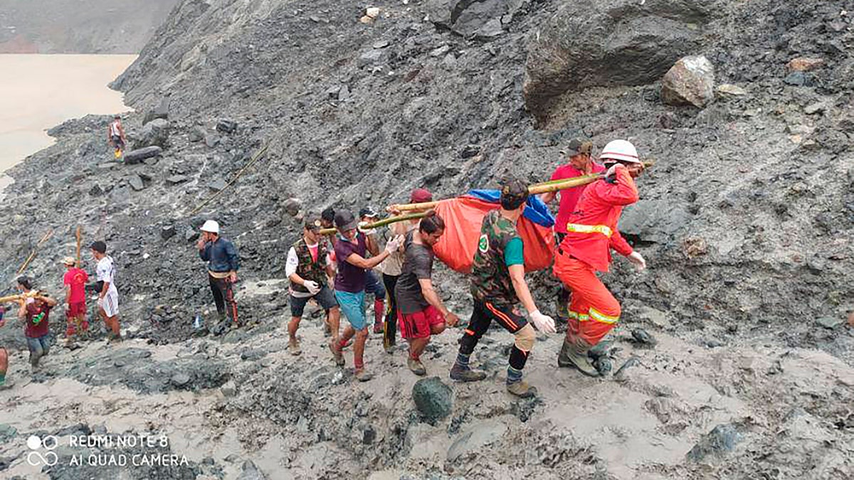In this photo released from Myanmar Fire Service Department, rescuers carry a recovered body of a victim of a landslide from a jade mining area in Hpakant, Kachine state, northern Myanmar July 2.