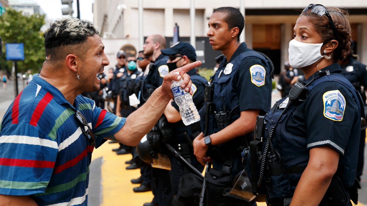 A man yells at a Metropolitan Police officer as demonstrators protest in front of a police line on the section of Washington, D.C., renamed Black Lives Matter Plaza, on June 23. (AP)