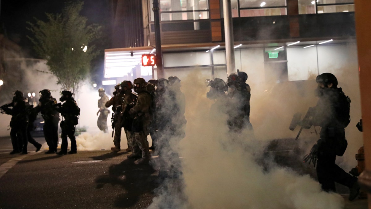 Federal law enforcement officials stand during a protest against racial inequality in Portland, Oregon, U.S., July 21, 2020. REUTERS/Caitlin Ochs - RC2KXH9ES8R1