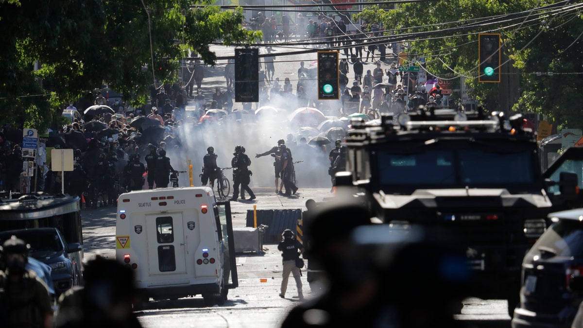 Smoke rises as police clash with protesters during a Black Lives Matter demonstration near the Seattle Police East Precinct headquarters on Saturday. (AP)