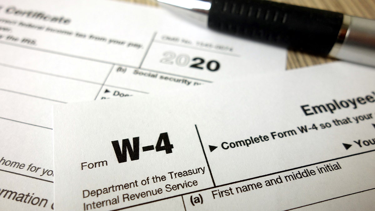 Blank W-4 form and a pen. Tax season