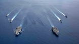 Two US aircraft carriers sail through the South China Sea. China has simulated attacks on US warships.