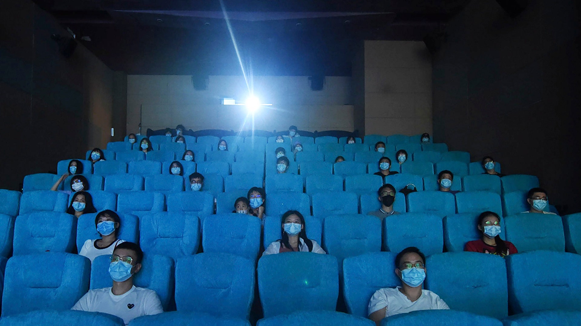 Movie-goers wearing masks to protect themselves from the coronavirus are spaced apart as they watch a movie in a newly reopened cinema in Hangzhou, China, July 20, 2020.