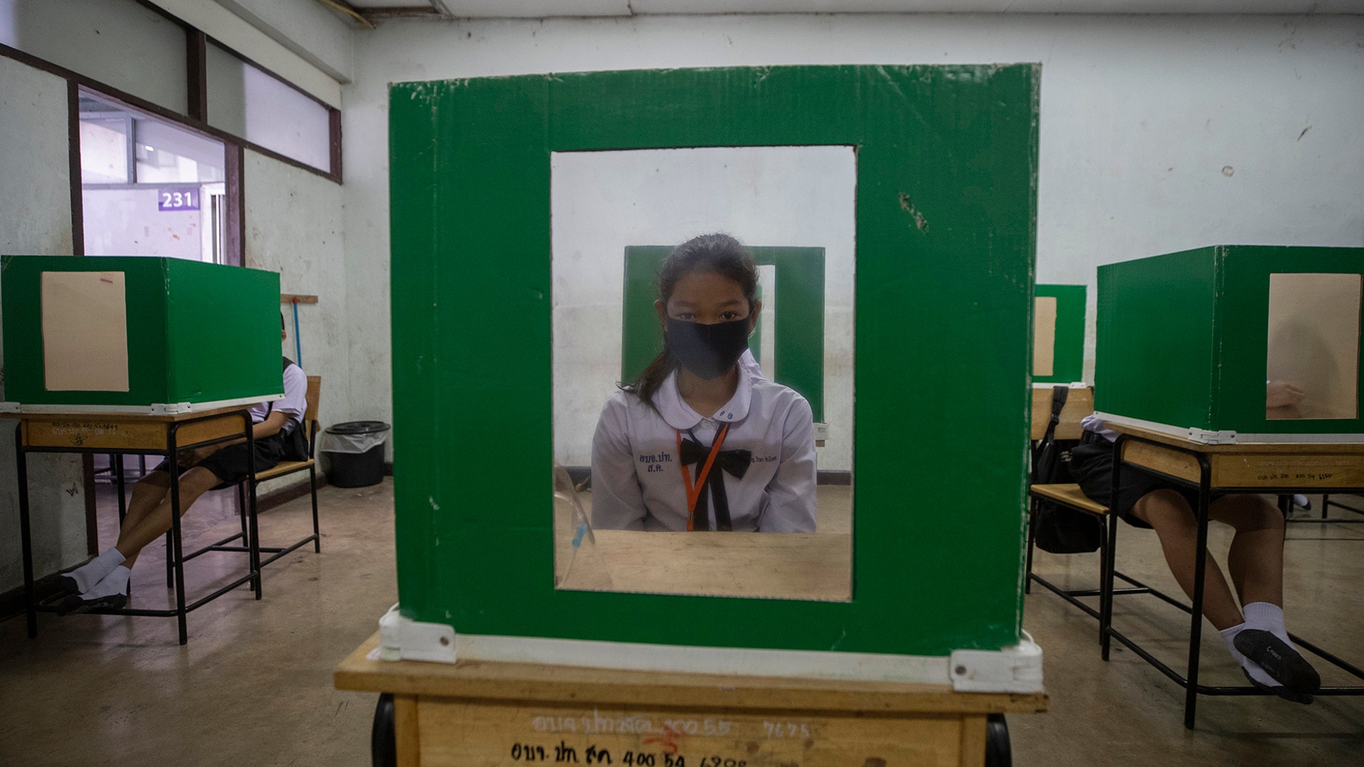 A student sits at her partitioned desk in a classroom at the Samkhok School in Pathum Thani, Thailand, July 1, 2020. 
