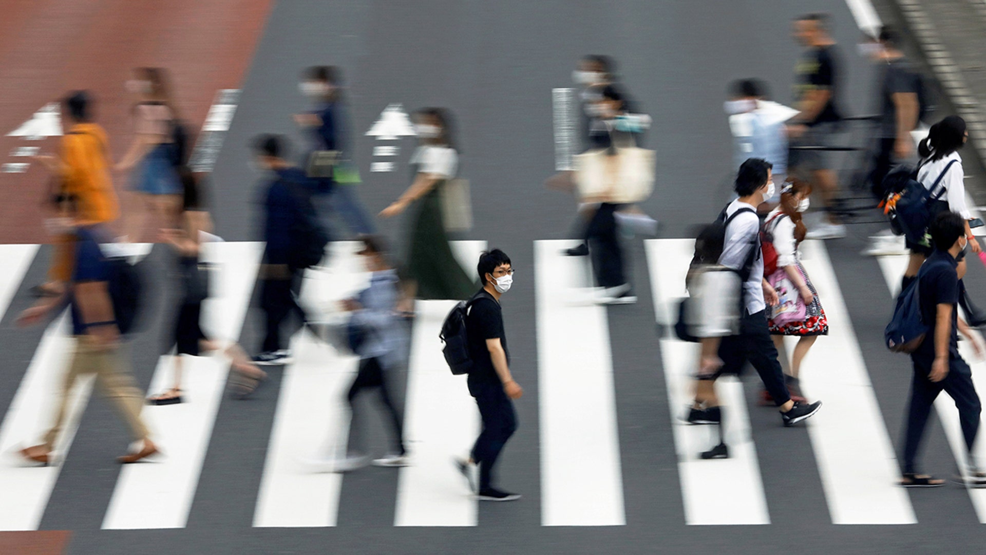 A man wearing a protective face mask crosses the street amid the coronavirus disease outbreak in Tokyo, Japan, July 30, 2020.