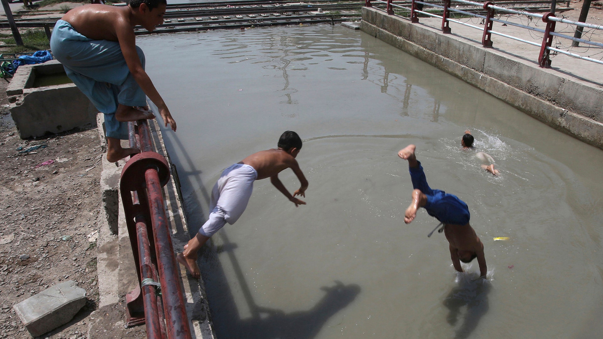 Youths swim to cool themselves off as the temperature soars in Peshawar, Pakistan, June 29, 2020. 