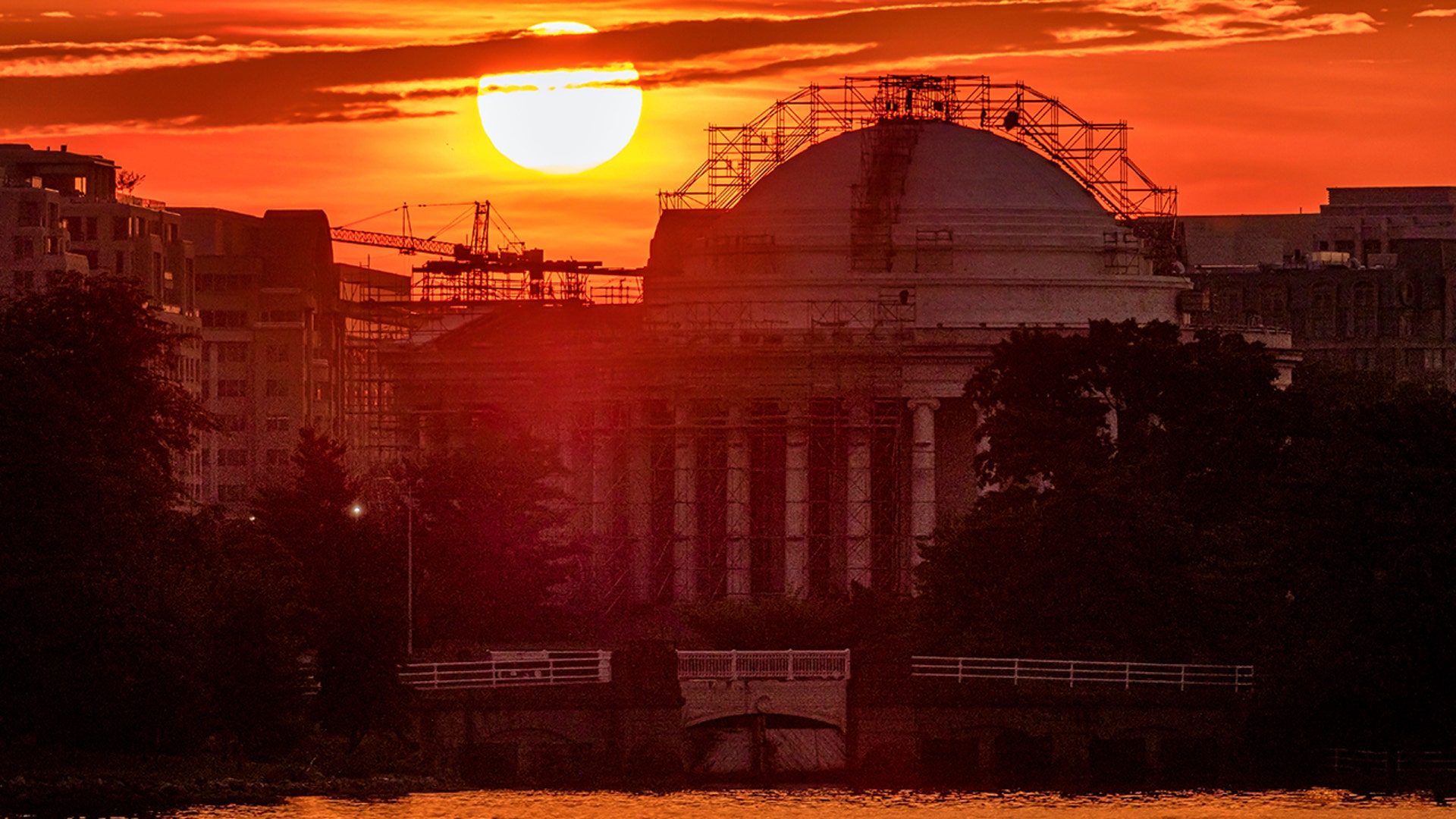 The sun rises behind the scaffolding-clad Jefferson Memorial to begin a hot day in Washington, July 20, 2020.