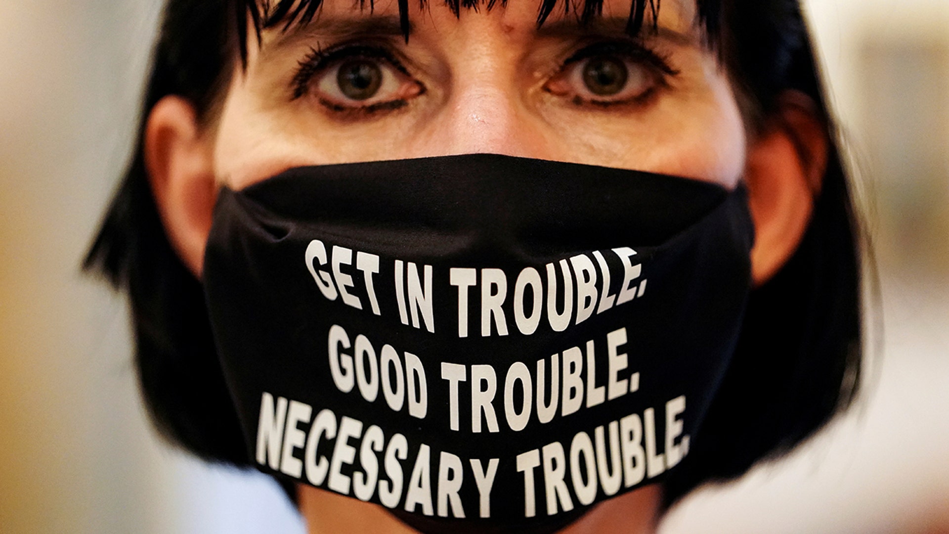 A woman wears a face mask with a quote from the late U.S. Congressman John Lewis at the Georgia State Capitol building, in Atlanta, July 29, 2020.