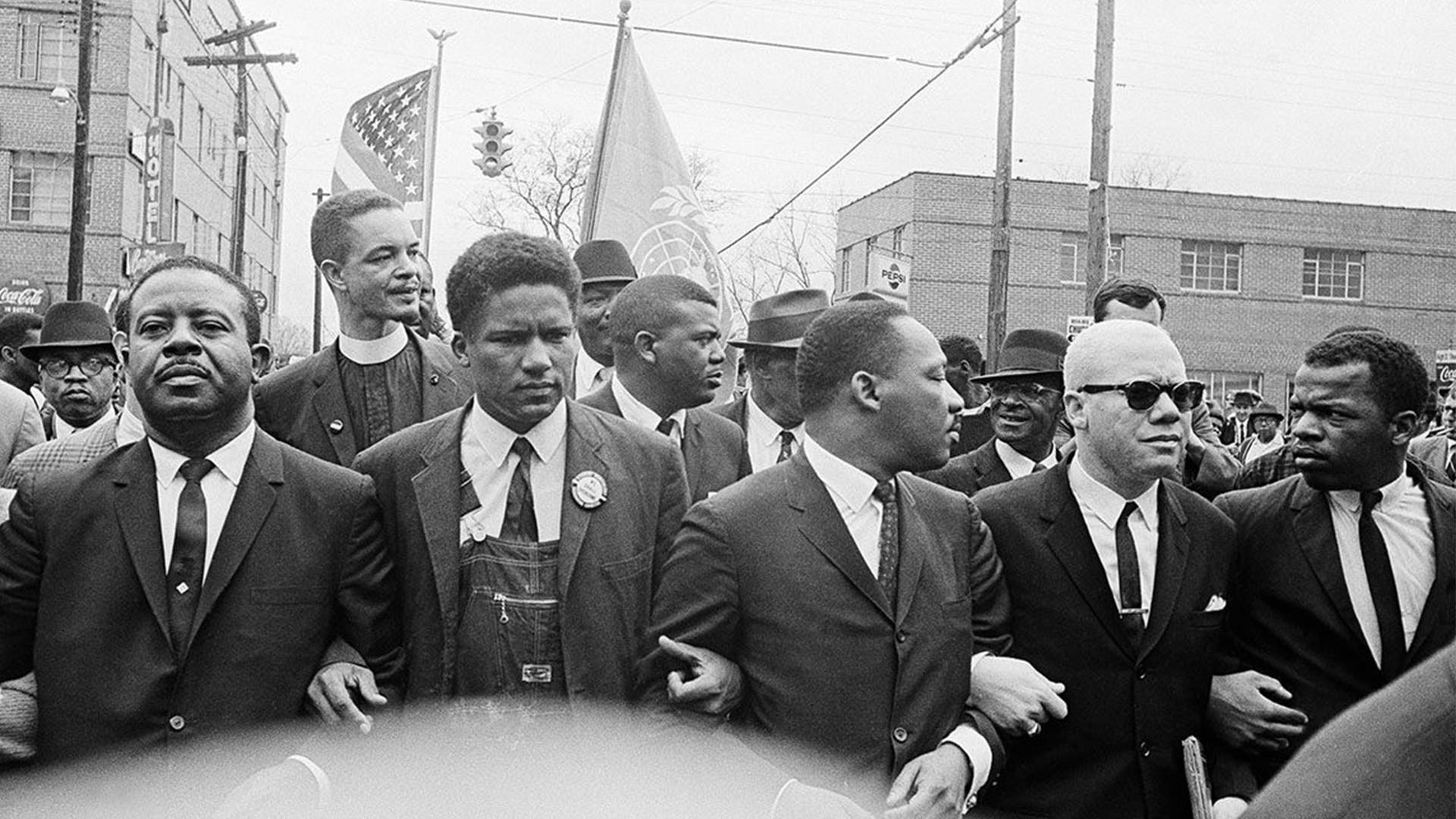 Dr. Martin Luther King Jr., center, foreground, locks arms with his aides as he leads a march of several thousands to the courthouse in Montgomery, AL, March 17, 1965. From left are: an unidentified woman, Rev. Ralph Abernathy, James Foreman, King, Jesse Douglas Sr., and John Lewis.