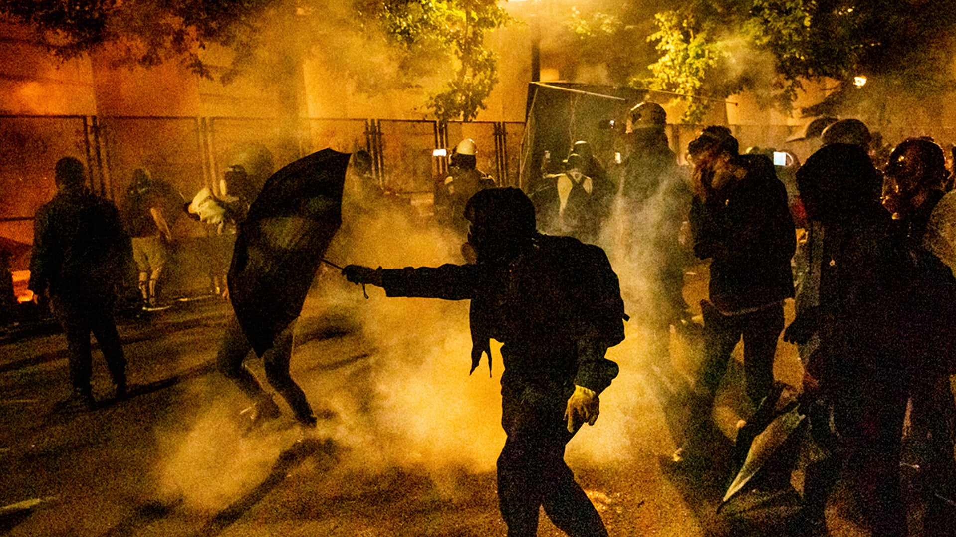 Protesters walk through chemical irritants dispersed by federal agents at the Mark O. Hatfield U.S. Courthouse on Thursday, July 23, 2020, in Portland, Ore.