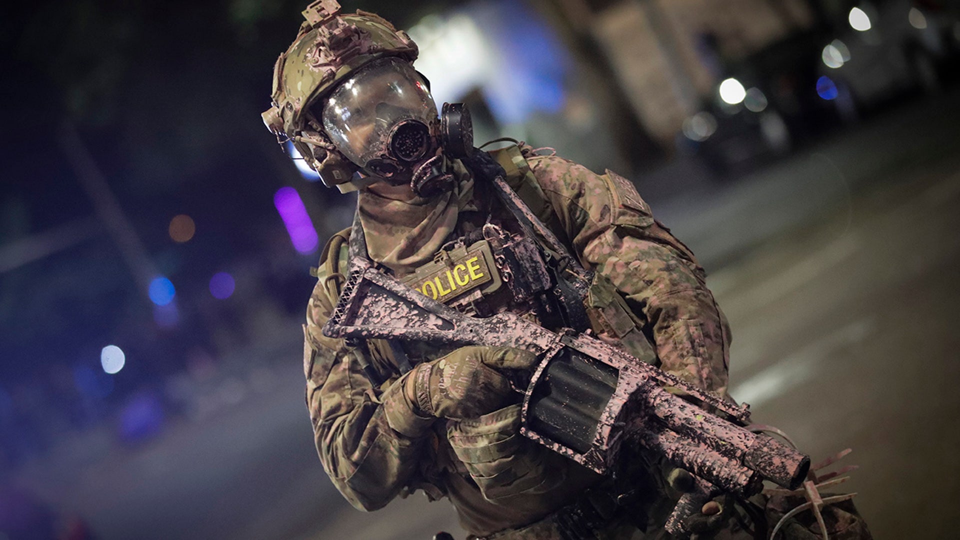 A federal officer holds a tear gas gun during a Black Lives Matter protest at the Mark O. Hatfield U.S. Courthouse early Sunday, July 26, 2020, in Portland, Ore.