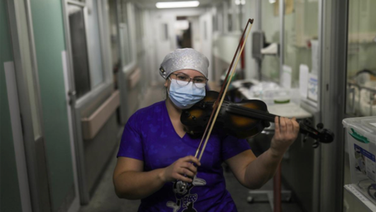 Chilean nurse plays violin for coronavirus patients, exhausted staff after finishing shift