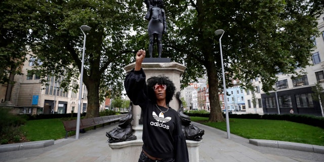 Jen Reid poses for photographs in front of the new statue Wednesday. (AP)