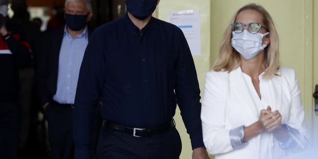 Presidential candidate Rafal Trzaskowski accompanied by his wife Malgorzata arrives to cast his vote during the presidential election runoff in Rybnik, Poland, Sunday, July 12, 2020. Voting started Sunday in Poland's razor-blade-close presidential election runoff between the conservative incumbent Andrzej Duda and liberal, pro-European Union Warsaw Mayor Rafal Trzaskowski.