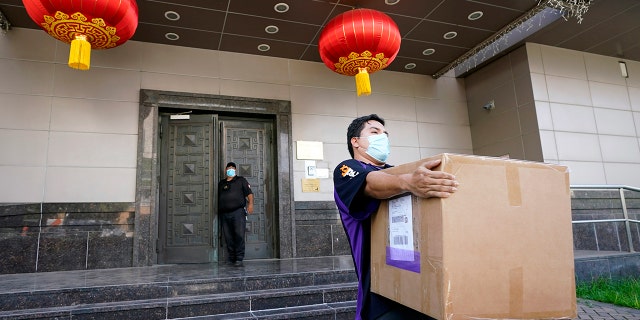 A FedEx employee removes a box from the Chinese Consulate in Houston on Thursday. (Associated Press)