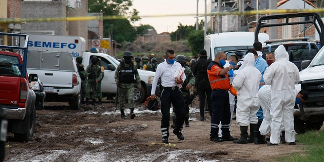 Forensic service personnel prepare to enter an unregistered drug rehabilitation center in Irapuato, Mexico, Wednesday, July 1, 2020. (Associated Press)