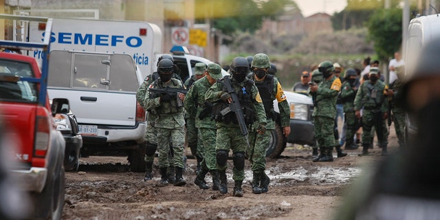 Members of the national guard walk near an unregistered drug rehabilitation center after a shooting in Irapuato, Mexico, Wednesday, July 1, 2020. (Associated Press)
