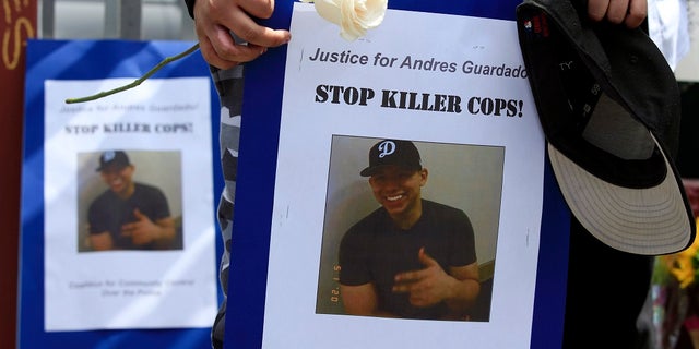 Mourners hold images of Andres Guardado, who was fatally shot by a Los Angeles County sheriff's deputy, at a memorial site in Gardena, Calif. (AP Photo/Damian Dovarganes, File)