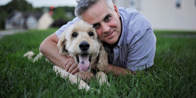 Jason Wright with Goldendoodle Pilgrim before trip to vet on his final morning