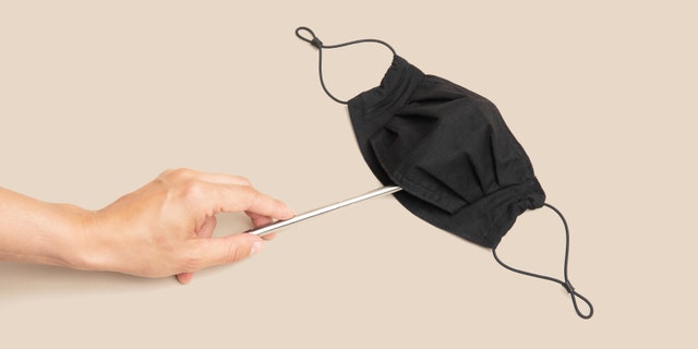 The cotton facial covering features a two-layer design and room for the wearer to insert a straw through a covered, unexposed opening.