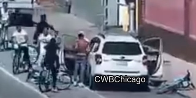 The alleged assailants yanked the victim out of his white SUV, tossed some of his belongings onto the street and left him standing on the side of the road as they sped off. (Courtesy: CWBChicago)