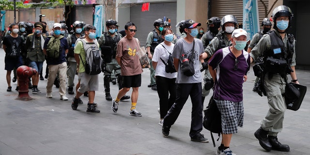Police detain protesters after a protest in Causeway Bay before the annual handover march in Hong Kong, Wednesday, July. 1, 2020. Hong Kong marked the 23rd anniversary of its handover to China in 1997, and just one day after China enacted a national security law that cracks down on protests in the territory. Hong Kong police said on Facebook they had arrested over 30 people on various charges, from unlawful assembly to the violation of a national security law on the first day of the law. (AP Photo/Kin Cheung)
