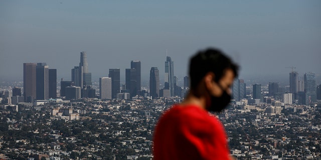 Izzy Galvan, 20, wears a face mask while visiting the Griffith Observatory overlooking downtown Los Angeles, Wednesday, July 15, 2020, in Los Angeles. (AP Photo/Jae C. Hong)