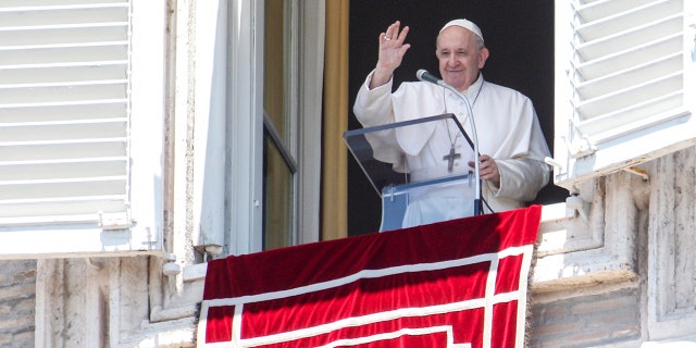 Pope Francis waves from his studio window overlooking St. Peter's Square at the Vatican on Sunday, July 5, 2020. (AP Photo/Riccardo De Luca)
