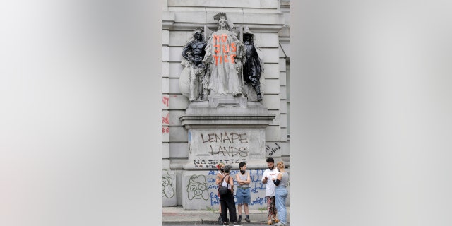 A building is defaced with graffiti across the street from an encampment of protesters near City Hall in New York, Tuesday, June 30, 2020. New York City lawmakers are holding a high-stakes debate on the city budget as activists demand a $1 billion shift from policing to social services and the city grapples with multibillion-dollar losses because of the coronavirus pandemic. (AP Photo/Seth Wenig)
