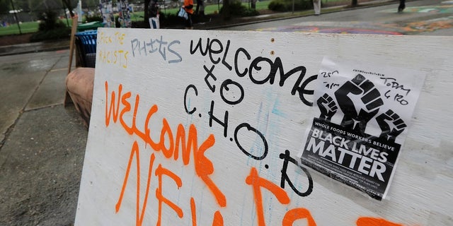 A sign on a makeshift barricade reads "Welcome to C.H.O.P." after Seattle Department of Transportation workers removed concrete barricades at the intersection of Tenth Avenue and Pine Street at the CHOP (Capitol Hill Occupied Protest) zone in Seattle. The area has been occupied by protesters since Seattle Police pulled back from their East Precinct building following violent clashes with demonstrators earlier in the month. (AP Photo/Ted S. Warren)