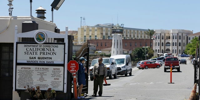 A Department of Corrections officer guards the main entryway leading into San Quentin State Prison in San Quentin, Calif. Corrections officials said Friday that up to 8,000 state prison inmates could be released in an effort to prevent the spread of the coronavirus in correctional facilities. (AP Photo/Eric Risberg, File)