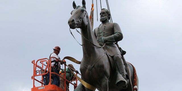 Work crews remove the statue of confederate general Stonewall Jackson, July 1, in Richmond, Va. Richmond Mayor Levar Stoney has ordered the immediate removal of all Confederate statues in the city, saying he was using his emergency powers to speed up the healing process for the former capital of the Confederacy amid weeks of protests over police brutality and racial injustice. (AP Photo/Steve Helber)