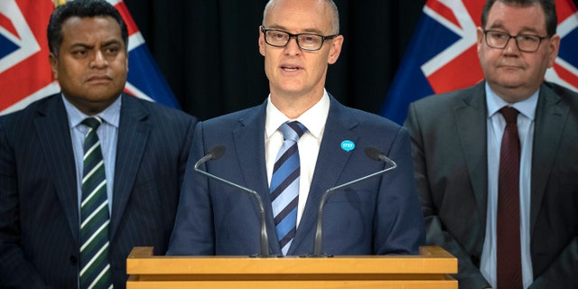 New Zealand Health Minister David Clark, center, flanked by Cabinet colleagues Grant Robertson, right, and Kris Faafoi addresses a press conference where he announced his resignation as Health Minister at parliament in Wellington, New Zealand, Thursday, July 2, 2020. (Mark Mitchell/New Zealand Herald via AP)