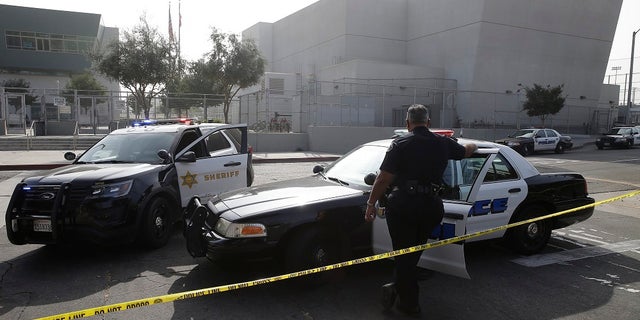 Los Angeles Sheriffs officers and Los Angeles Unified School District police officers guard the campus of Esteban Torres High School in unincorporated East Los Angeles. (AP Photo/Damian Dovarganes, File)