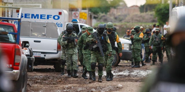 Members of the Mexico national guard walk near an unregistered drug rehabilitation center after a shooting in Irapuato, Mexico, on July 1. The violence occured in a region where the Jalisco New Generation Cartel reportedly is fighting for control of a $3 billion market in stolen gasoline. (AP)