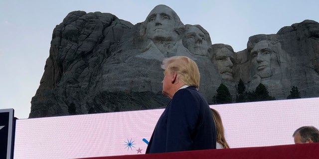 President Donald Trump watches as planes perform fly-overs of the Mount Rushmore National Monument Friday, July 3, 2020, in Keystone, S.D. (Associated Press)